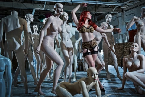 Girl posing amongst many mannequins